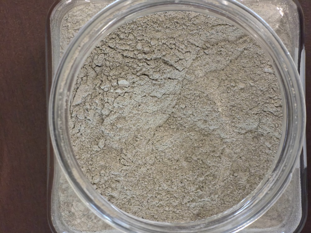 Fly ash waste sample: fine grey powder from coal combustion in a jar